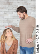 man holds hand above womans head. Стоковое фото, агентство Ingram Publishing / Фотобанк Лори