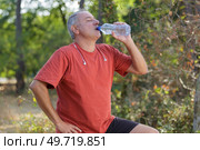 Middle aged man drinking water from bottle. Стоковое фото, агентство Ingram Publishing / Фотобанк Лори