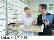 salesman looking in open drawer with pharmacist. Стоковое фото, агентство Ingram Publishing / Фотобанк Лори