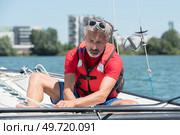 mature man enjoying sailing on a lake. Стоковое фото, агентство Ingram Publishing / Фотобанк Лори