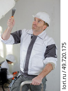 plasterer renovating indoor walls and ceilings with float and plaster. Стоковое фото, агентство Ingram Publishing / Фотобанк Лори