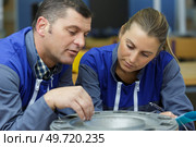 young male and female technicians in metalworks factory. Стоковое фото, агентство Ingram Publishing / Фотобанк Лори