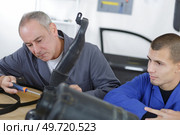 apprentice mechanic holding engine block. Стоковое фото, агентство Ingram Publishing / Фотобанк Лори