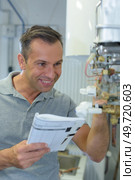 happy plumber repairing an hot-water heater. Стоковое фото, агентство Ingram Publishing / Фотобанк Лори