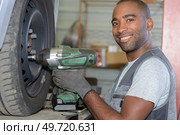 a man is unbolting the rim bolts. Стоковое фото, агентство Ingram Publishing / Фотобанк Лори