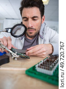 man using plier to assemble printed circuit board. Стоковое фото, агентство Ingram Publishing / Фотобанк Лори