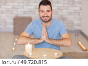 sporty mindful man meditating alone at home. Стоковое фото, агентство Ingram Publishing / Фотобанк Лори