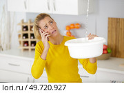 woman calling to plumber for water leakage problem. Стоковое фото, агентство Ingram Publishing / Фотобанк Лори