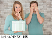 pretty woman surprising her boyfriend with gift. Стоковое фото, агентство Ingram Publishing / Фотобанк Лори