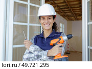 portrait of female builder holding screwdriver and cordless equivalent. Стоковое фото, агентство Ingram Publishing / Фотобанк Лори
