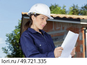 woman builder architect holding paper blueprints. Стоковое фото, агентство Ingram Publishing / Фотобанк Лори
