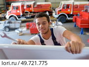 young handsome mechanic repairing motorbike in workshop. Стоковое фото, агентство Ingram Publishing / Фотобанк Лори
