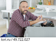 lost plumber with clipboard near washing machine. Стоковое фото, агентство Ingram Publishing / Фотобанк Лори