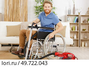 disabled man on wheelchair vacuum cleaning house. Стоковое фото, агентство Ingram Publishing / Фотобанк Лори