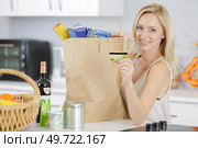 woman with credit card and shopping bags in kitchen. Стоковое фото, агентство Ingram Publishing / Фотобанк Лори