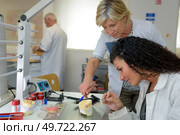 technician and apprentice polishing a dental implant. Стоковое фото, агентство Ingram Publishing / Фотобанк Лори