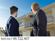 suited men pointing to the roof of a property. Стоковое фото, агентство Ingram Publishing / Фотобанк Лори