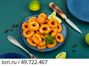 Baked breaded calamari rings served with lime. Rings of squid. Стоковое фото, агентство Ingram Publishing / Фотобанк Лори