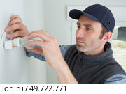 man fitting a low energy cfl light bulb. Стоковое фото, агентство Ingram Publishing / Фотобанк Лори