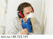 a man sanding a wall. Стоковое фото, агентство Ingram Publishing / Фотобанк Лори