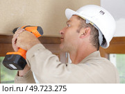 hardworker man drilling a wooden frame. Стоковое фото, агентство Ingram Publishing / Фотобанк Лори