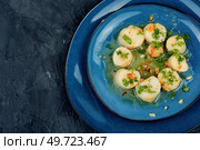 Delicious roasted scallops with green on a plate, seafood. Top view.. Scallops seared in garlic, space for text. Стоковое фото, агентство Ingram Publishing / Фотобанк Лори