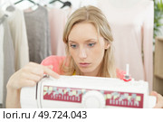 attractive caucasian seamstress working stitching with sewing machine. Стоковое фото, агентство Ingram Publishing / Фотобанк Лори