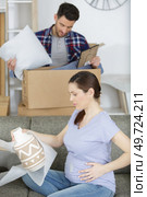 sorrowful pregnant woman looking at boxes with things. Стоковое фото, агентство Ingram Publishing / Фотобанк Лори