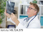 mature doctor looking at xrays. Стоковое фото, агентство Ingram Publishing / Фотобанк Лори