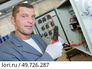 an electrician using wire strippers. Стоковое фото, агентство Ingram Publishing / Фотобанк Лори