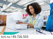 young female dressmaker using sewing machine. Стоковое фото, агентство Ingram Publishing / Фотобанк Лори