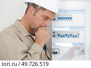 portrait of electrician standing next to fuseboard. Стоковое фото, агентство Ingram Publishing / Фотобанк Лори
