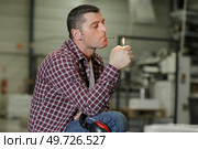 man smokes a cigar across from the factory. Стоковое фото, агентство Ingram Publishing / Фотобанк Лори
