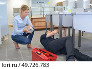 male plumber repairing female clients sink. Стоковое фото, агентство Ingram Publishing / Фотобанк Лори