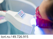 dental client in front of an ultra violet machine. Стоковое фото, агентство Ingram Publishing / Фотобанк Лори