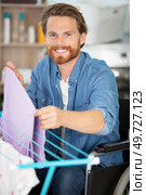 disabled man on wheelchair doing laundry. Стоковое фото, агентство Ingram Publishing / Фотобанк Лори