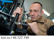 senior man installing hitch car with a wrench. Стоковое фото, агентство Ingram Publishing / Фотобанк Лори