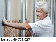 a worker is installing glass wool. Стоковое фото, агентство Ingram Publishing / Фотобанк Лори