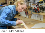 woman sanding a wood block. Стоковое фото, агентство Ingram Publishing / Фотобанк Лори
