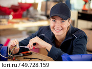 smiling woman measuring electrical current. Стоковое фото, агентство Ingram Publishing / Фотобанк Лори