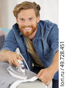 happy young man ironing at home. Стоковое фото, агентство Ingram Publishing / Фотобанк Лори
