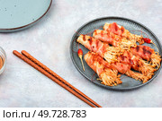 Enoki mushrooms appetizer fried in bacon. Bacon and enoki mushroom roll. Asian cuisine. Enoki mushrooms appetizer fried in bacon. Стоковое фото, агентство Ingram Publishing / Фотобанк Лори