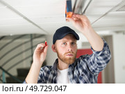 man measuring the ceiling with a construction level. Стоковое фото, агентство Ingram Publishing / Фотобанк Лори