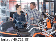 couple in motorcycle showroom holding brochure. Стоковое фото, агентство Ingram Publishing / Фотобанк Лори