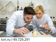 two chefs decorating chocolate egg. Стоковое фото, агентство Ingram Publishing / Фотобанк Лори