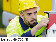 reefer container technician is repairing machinery. Стоковое фото, агентство Ingram Publishing / Фотобанк Лори