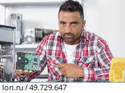 man repairman repairing pc at service center. Стоковое фото, агентство Ingram Publishing / Фотобанк Лори