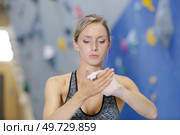 woman wall climber applying chalks in her hands. Стоковое фото, агентство Ingram Publishing / Фотобанк Лори