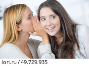 one friend is whispering a secret to the other. Стоковое фото, агентство Ingram Publishing / Фотобанк Лори