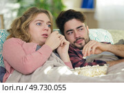 a young couple on the couch watching tv. Стоковое фото, агентство Ingram Publishing / Фотобанк Лори